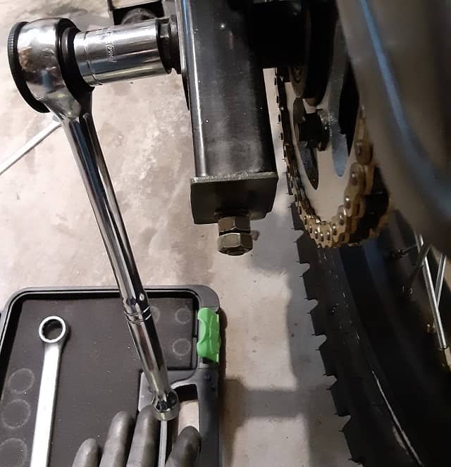 Socket wrench on TBR7 rear axle bolt.