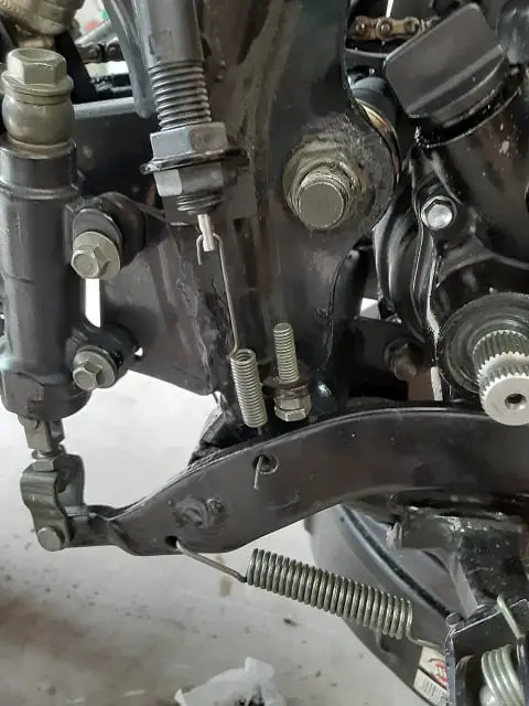 Inserting brake switch spring into rear brake pedal hole.