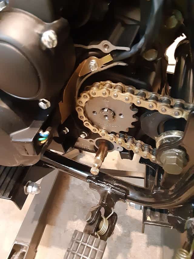 Chain wrapped over sprocket, and both installed on output shaft.