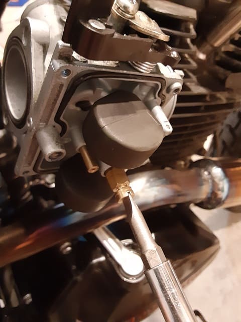 Installing main jet in carburetor.