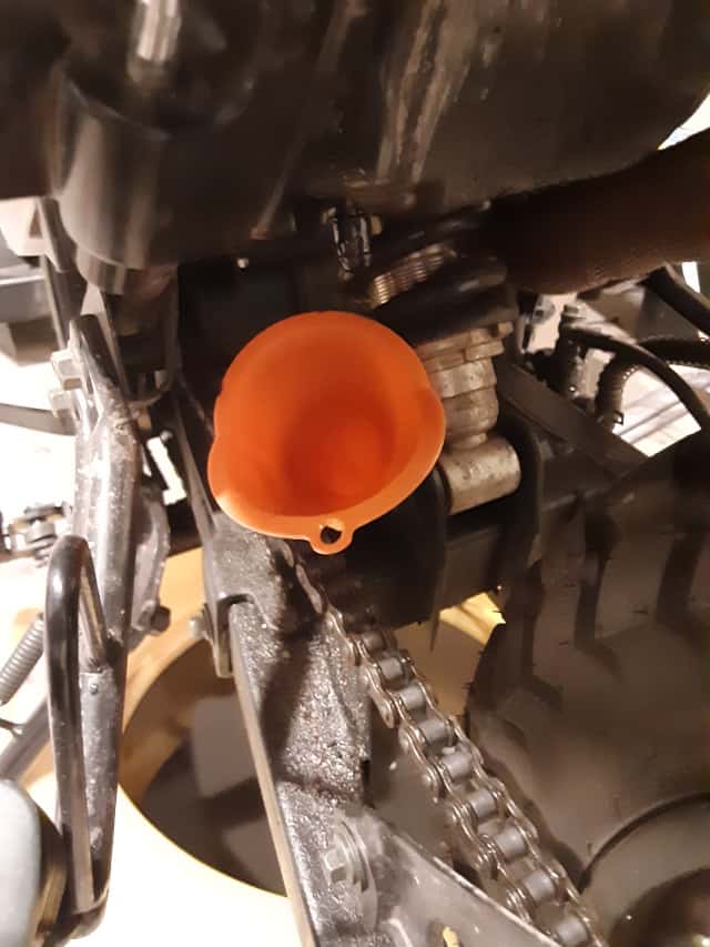 Funnel in position to drain oil from air box.