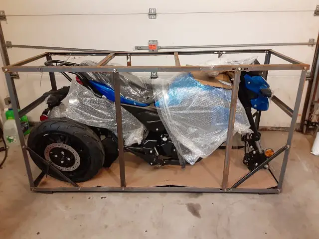 Boom Vader motorcycle is shown built to fit in a tiny crate for home final assembly.  