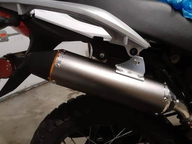 Muffler installed with new mounting bolt at new site.