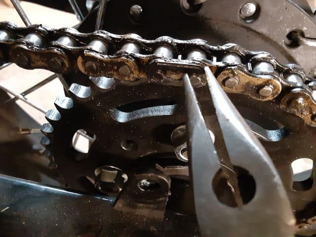 I used needle nose pliers to remove the motorcycle chain master link locking clip.