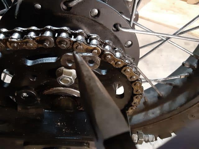 Motorcycle chain master link plate removed.