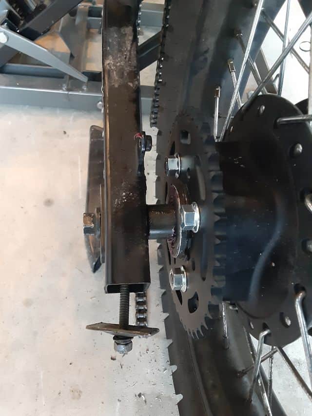 Rear left motorcycle chain tensioner very loose.