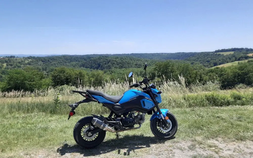 Boom Vader Gen 2 125cc motorcycle with green hills in background.
