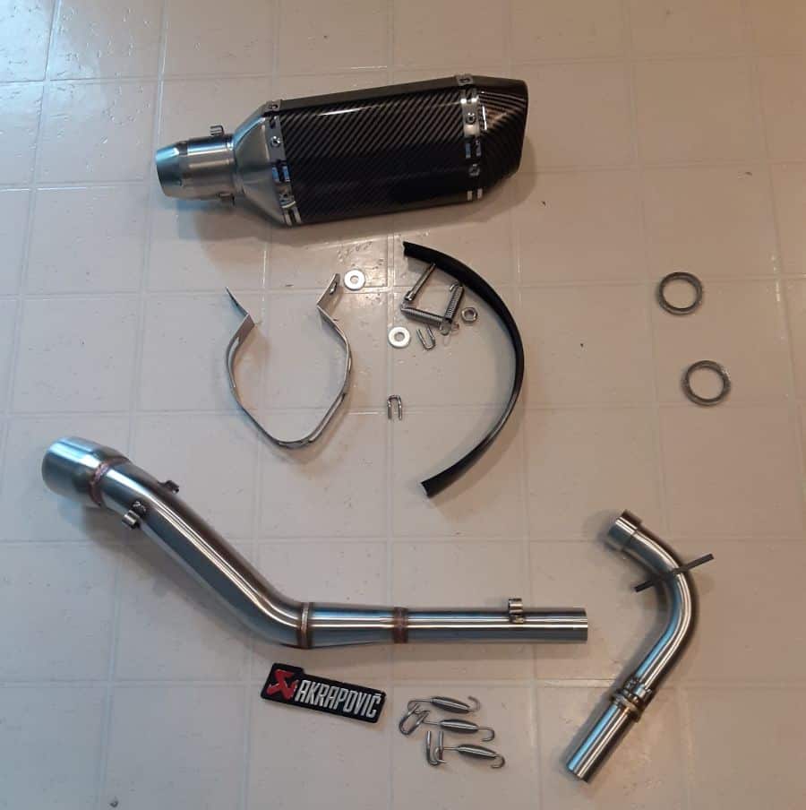 Boom Vader BD125-10 Exhaust Upgrade Setup for a Grom Clone parts laid out on floor.