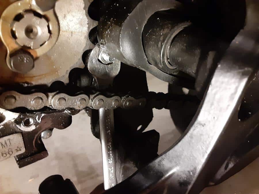 Open end wrench reaches motor mount nut without removing rear set and chain.