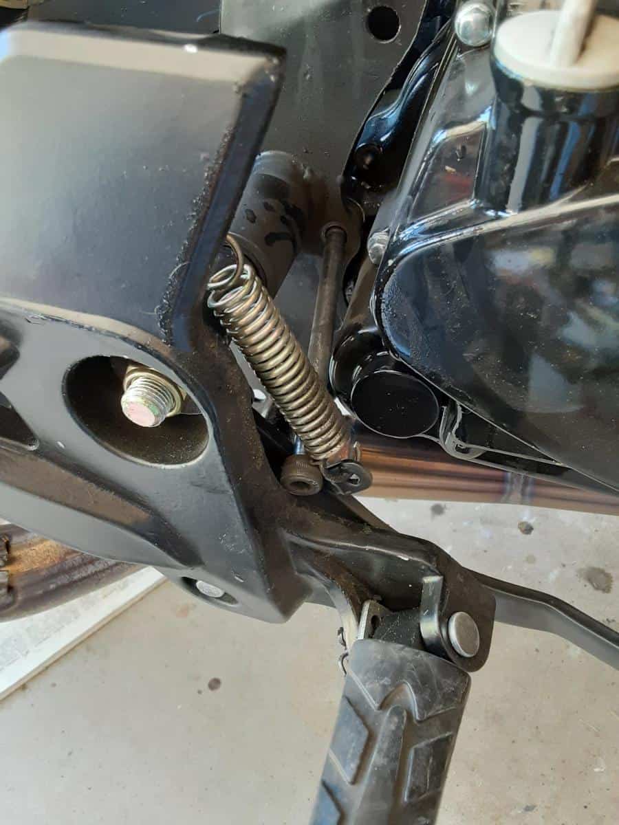 Right side of motorcycle, broken motor mount bolt sticking out.