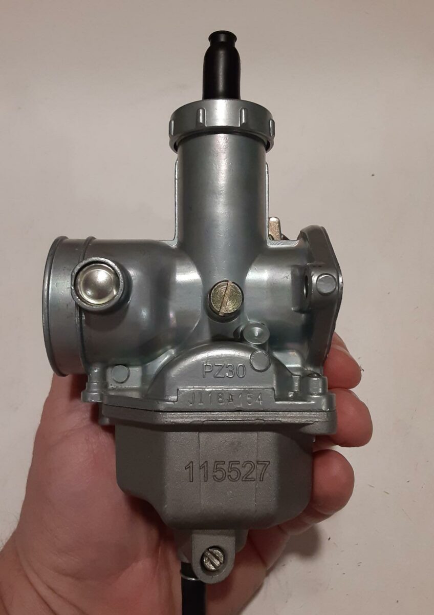 Stock TBR7 motorcycle carburetor, with idle speed screw visible.