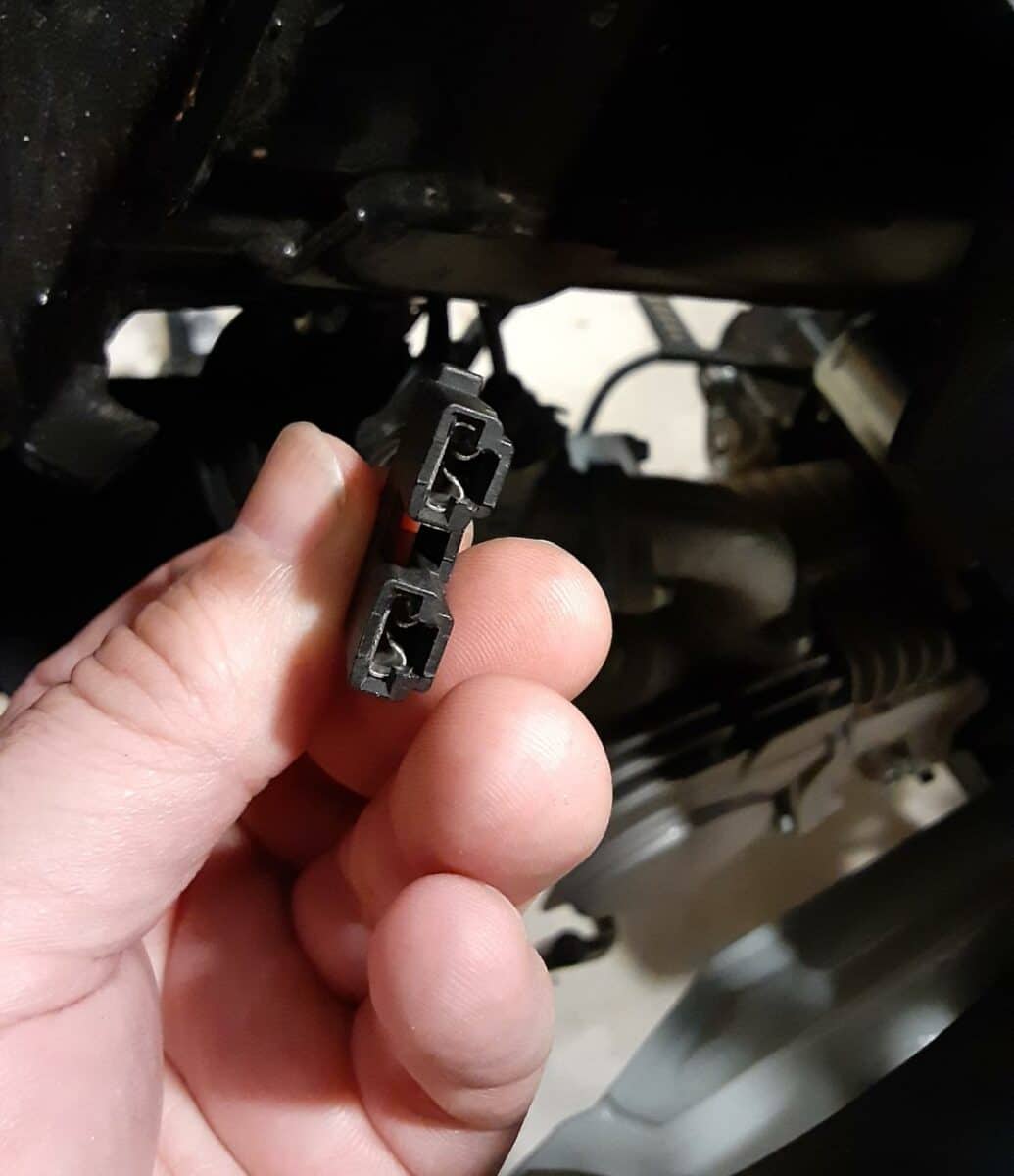 Stock motorcycle horn electrical connectors in a plastic mount.