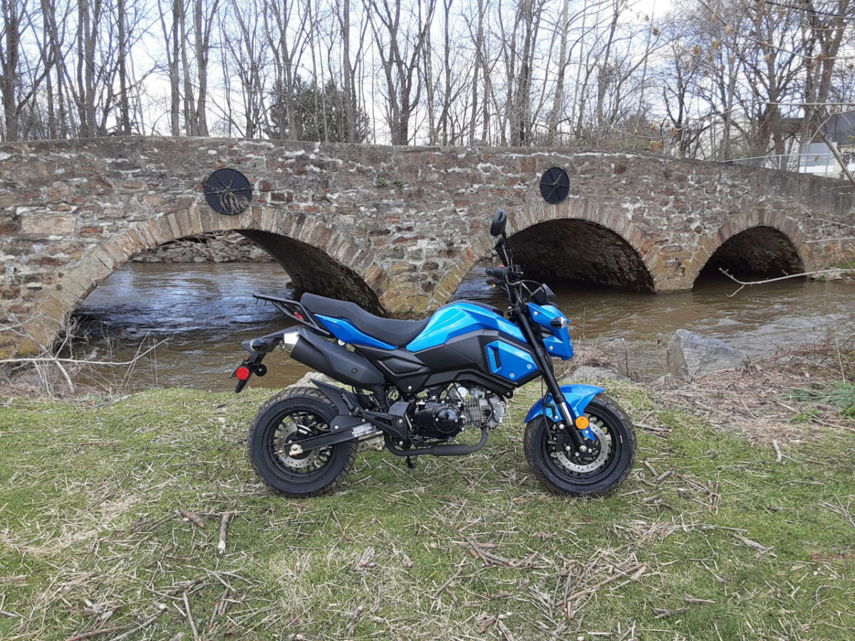 Boom Vader 125cc Motorcycle out for a ride with bridge in background.