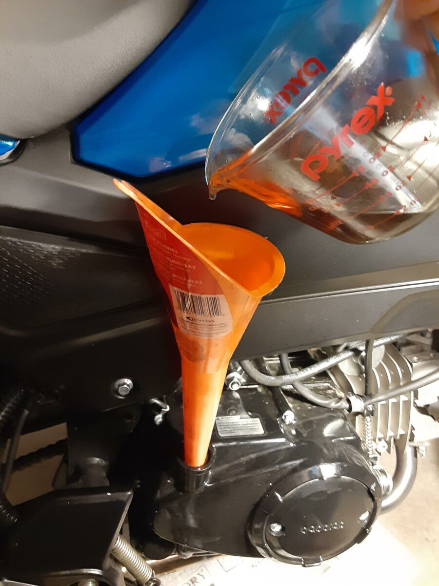Adjusting the motorcycle engine oil level if necessary.  